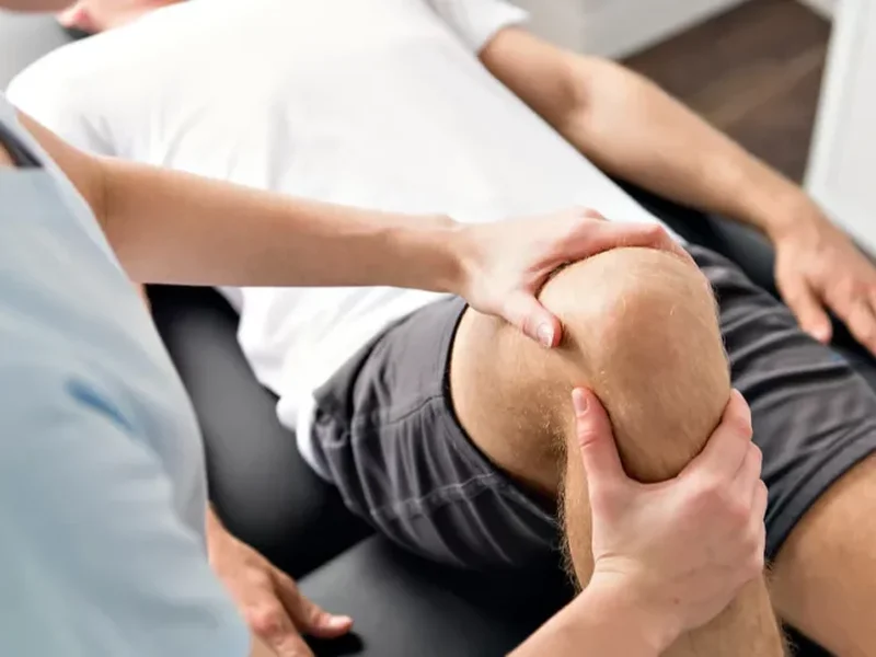 Physical therapist assessing a patient's movement related to knee pain