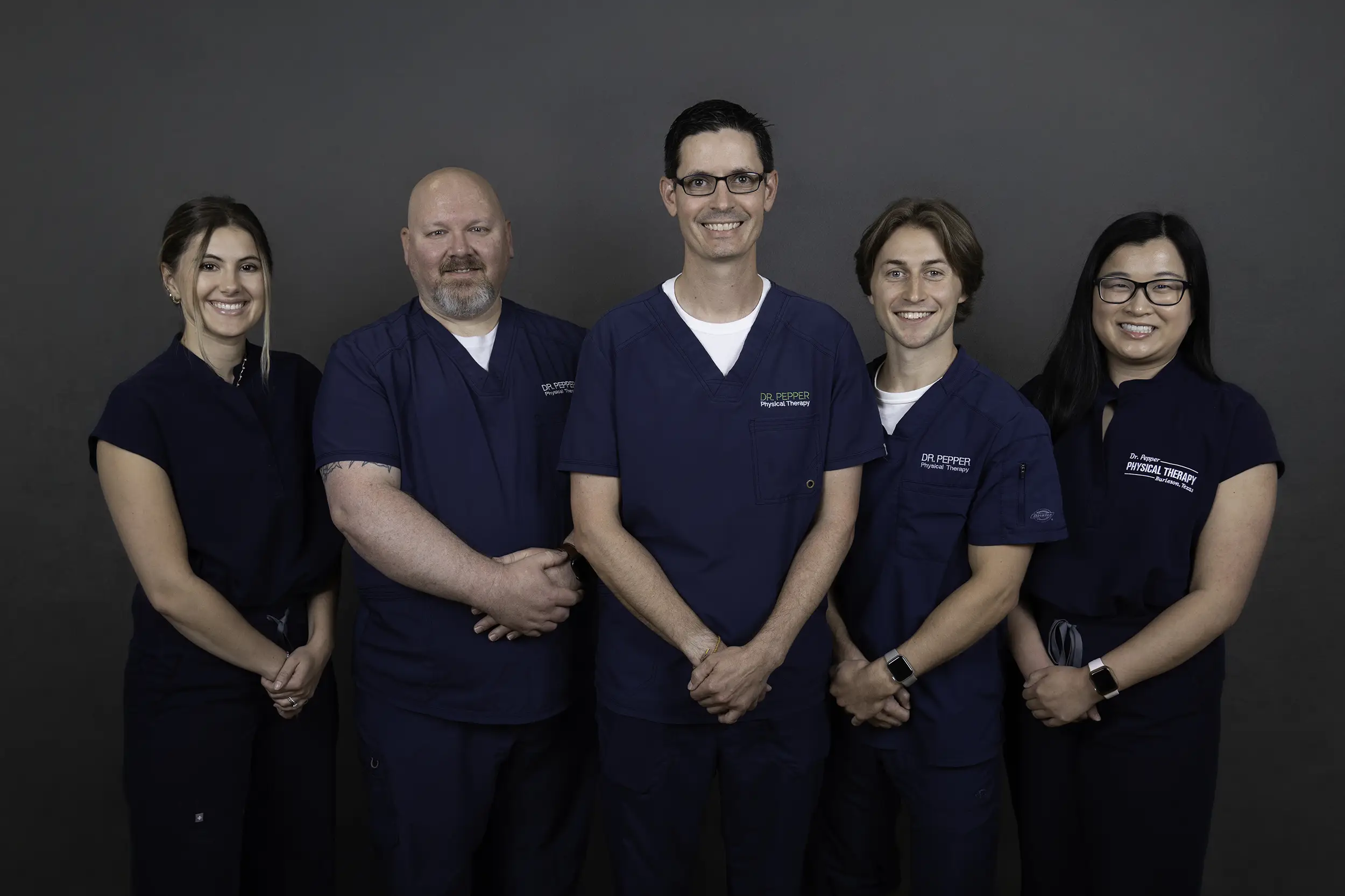 The Dr. Pepper Physical Therapy team of therapists together in clinic scrubs