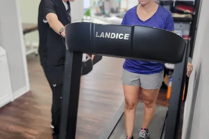 A patient doing gait training on a treadmill on the treatment floor at Dr. Pepper Physical Therapy