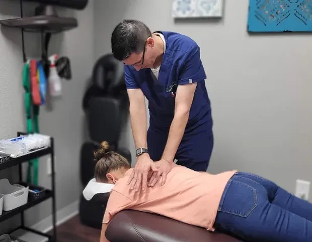 A Dr. Pepper Physical Therapy team member performing hands-on manual therapy on a patient